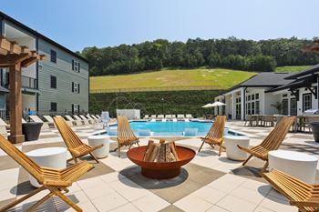 A large outdoor patio with a pool and chairs